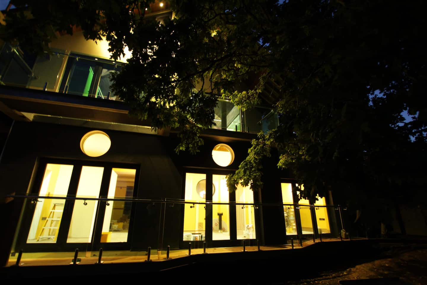 Belmont Deco Noir at night with porthole windows glowing