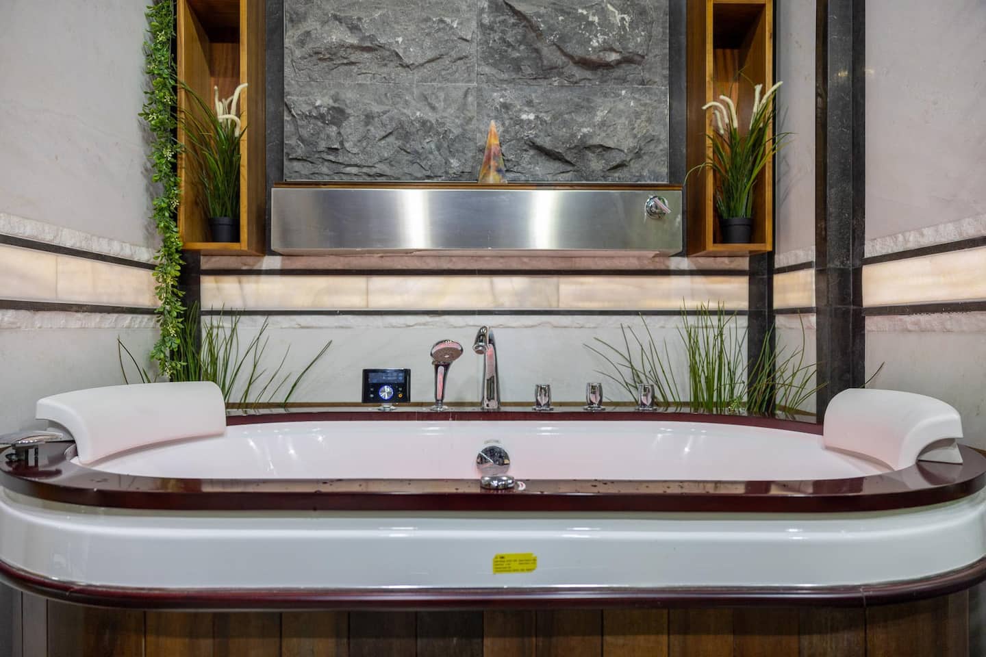 Two-person hydro-massage jacuzzi with 1500kg hand-carved natural rock waterfall — penthouse Bristol
